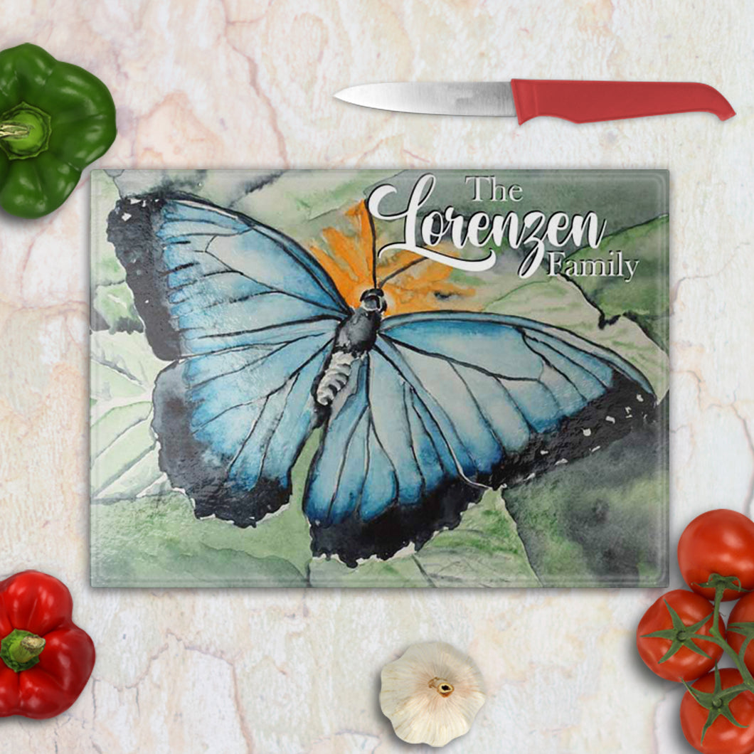 Tempered glass cutting board with a delicate watercolor butterfly in soft pastel tones – elegant farmhouse kitchen accent.