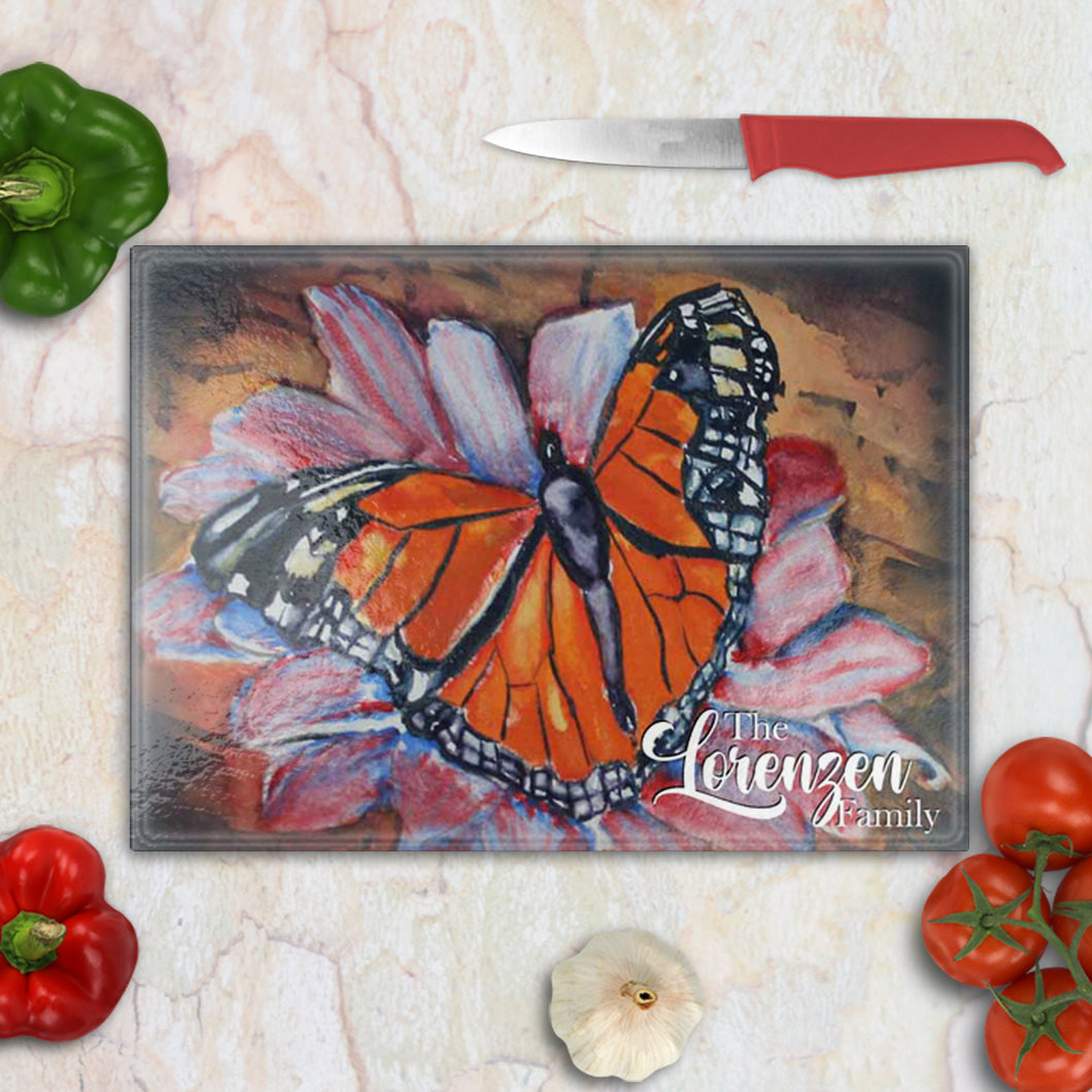 Tempered glass cutting board with a single large monarch butterfly in vivid orange and black – bold and artistic kitchen decor.
