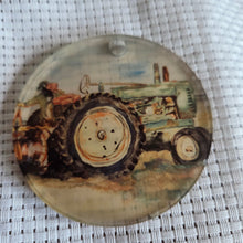 Load image into Gallery viewer, Round translucent decorative ornament featuring a bold tractor design on a textured white background.
